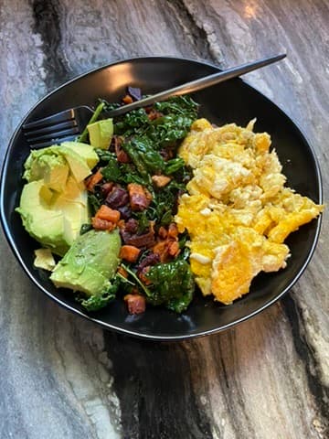 Scrambled eggs with sauteed kale, sweet potato, and avocado